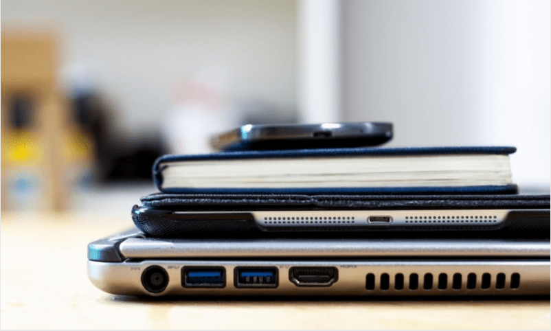 celular, livro e tablet em uma mesa